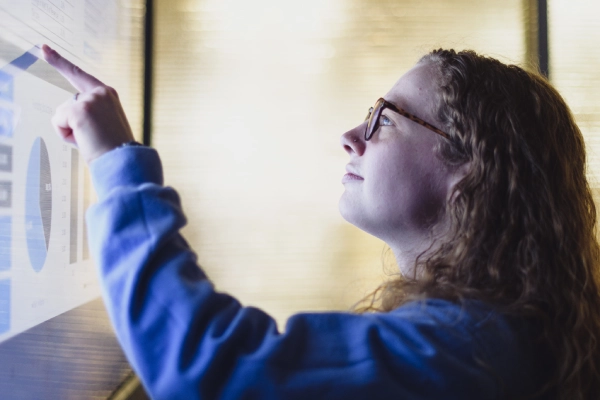 student pointing at large screen
