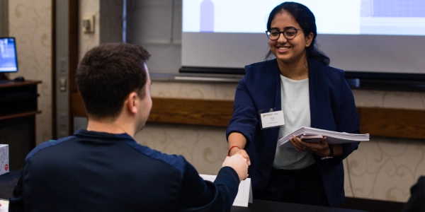 student and judge shaking hands at case competition