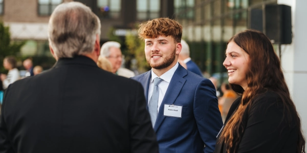businessman in conversation with two students