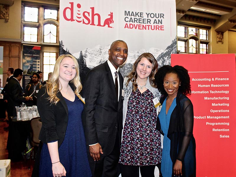 Students and recruiters pose for a photo at a Dish Network booth