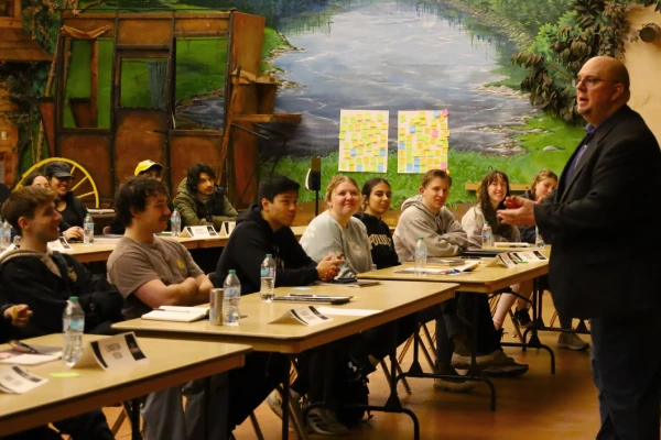 Visitor guide speaking to students in workshop