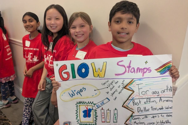Fourth grade students holding up poster