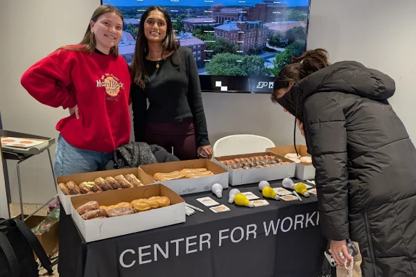 Student council members working at table with donuts and coffee