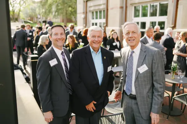 Three gentlemen smiling at the camera