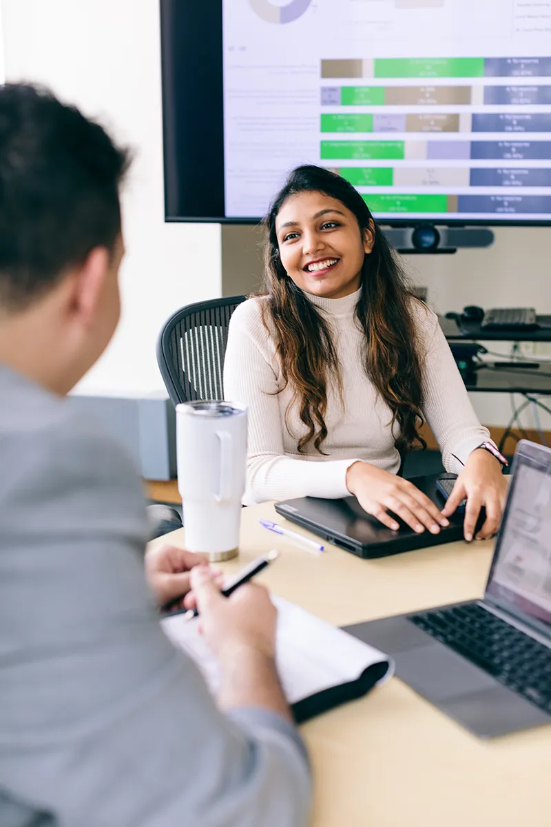 Female student in a meeting with data displayed in the background