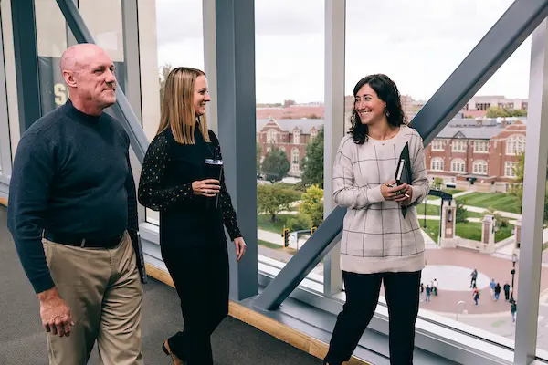 Three people walk along the Krannert-Rawls Skybridge at Purdue