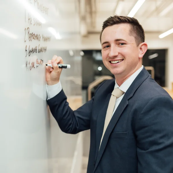 Daniels School graduate student writing on whiteboard