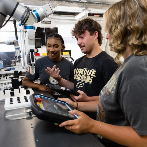 Three undergraduates collaborate in a robotics lab