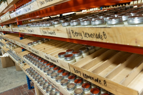 candles sorted by scent on a warehouse shelf