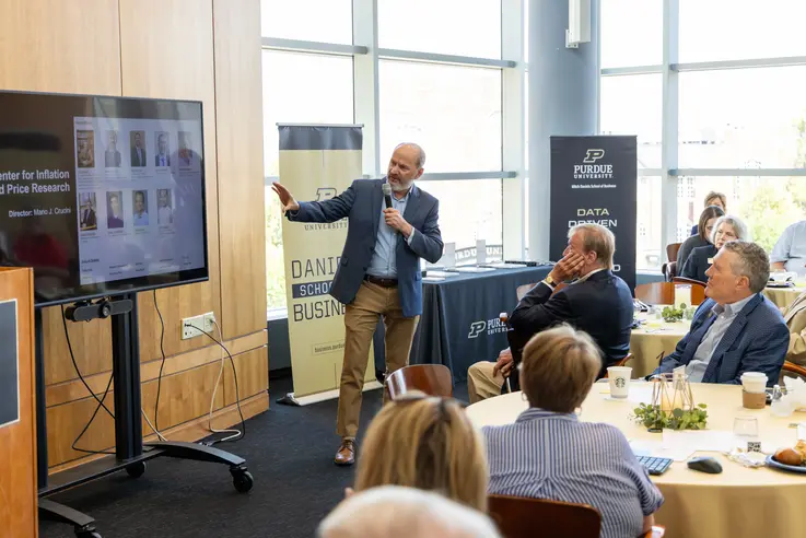 Crucini points to mobile display of slides during presentation