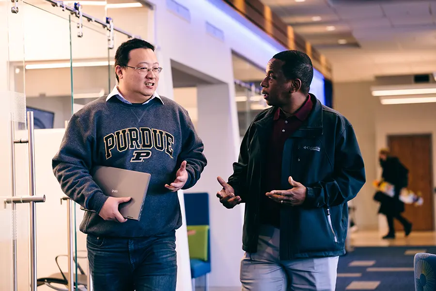 Two students speak in the Krannert Drawing Room