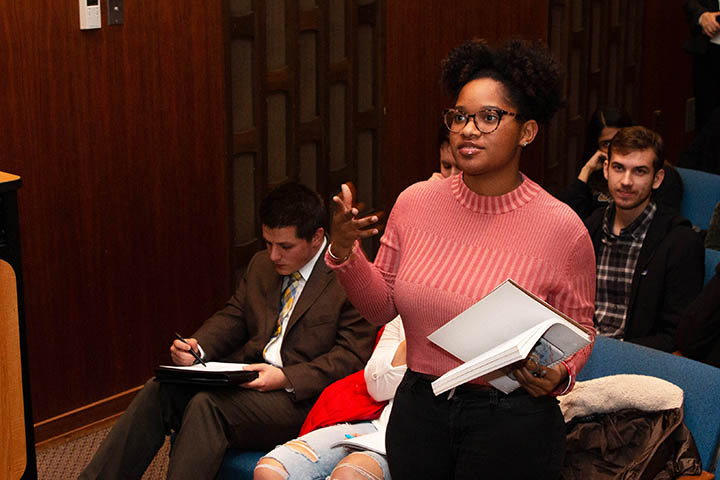 A student asks questions of an executive during a lecture series