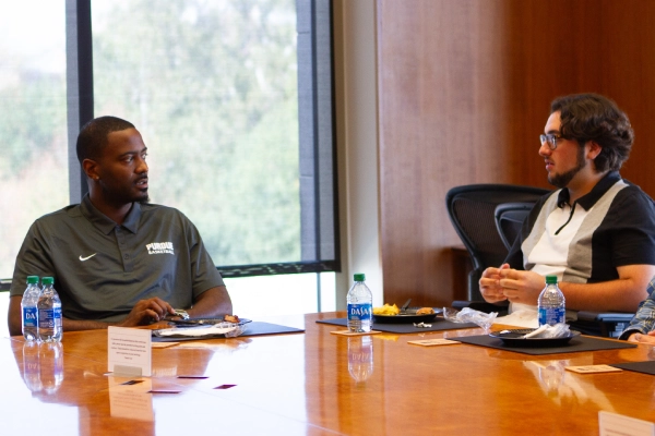 Student and professional talking at conference table